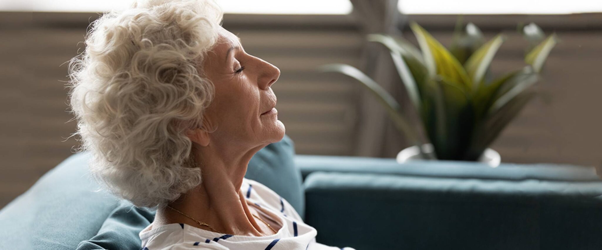 elderly woman sitting on a couch with her eyes closed
