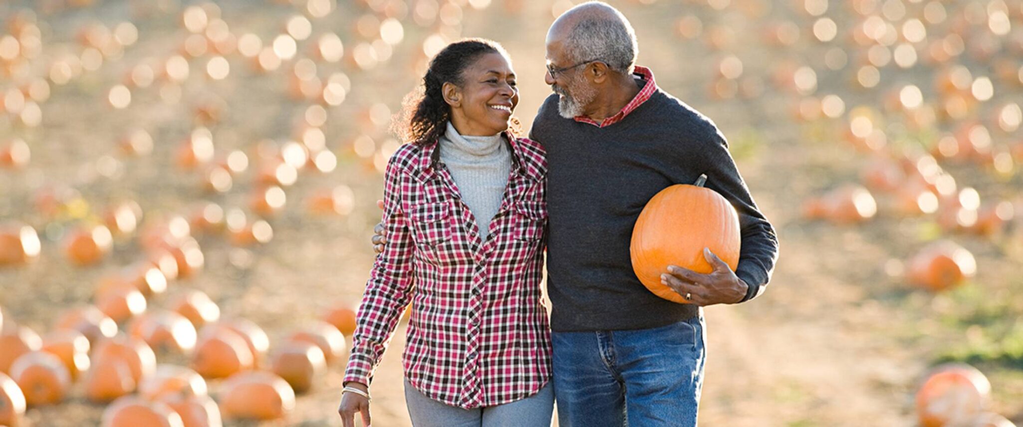 senior couple enjoy picking a pumpkin at a pumpkin patch