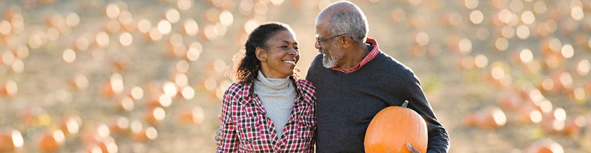 senior couple enjoy picking a pumpkin at a pumpkin patch