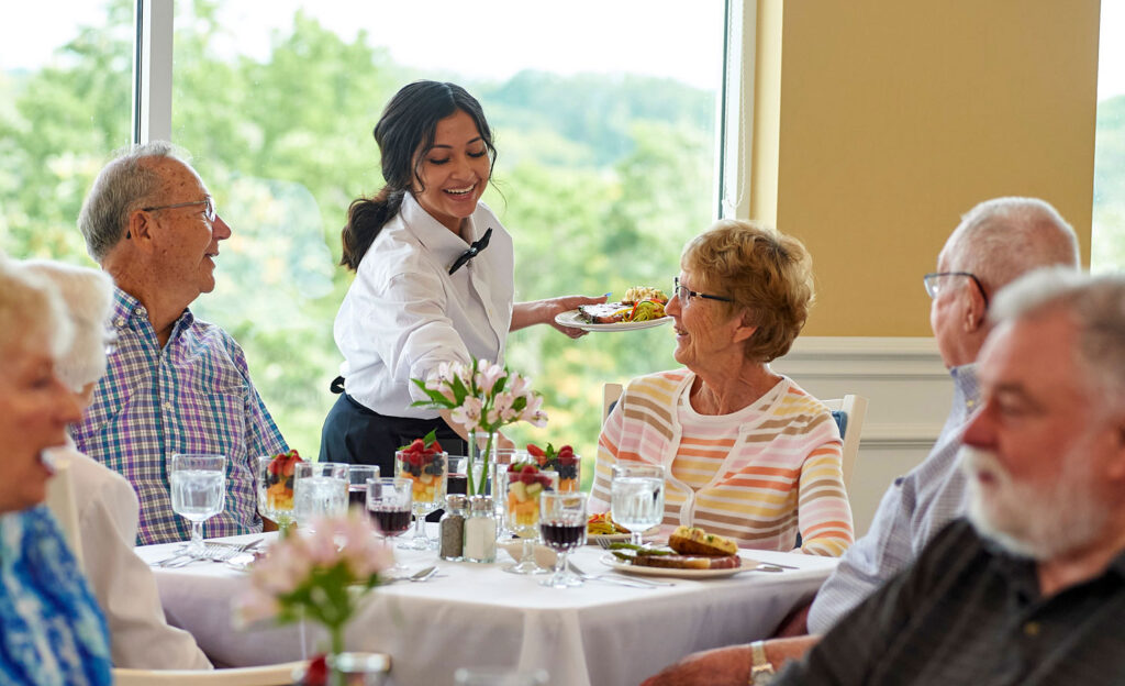 waitress serving female resident in the dining room