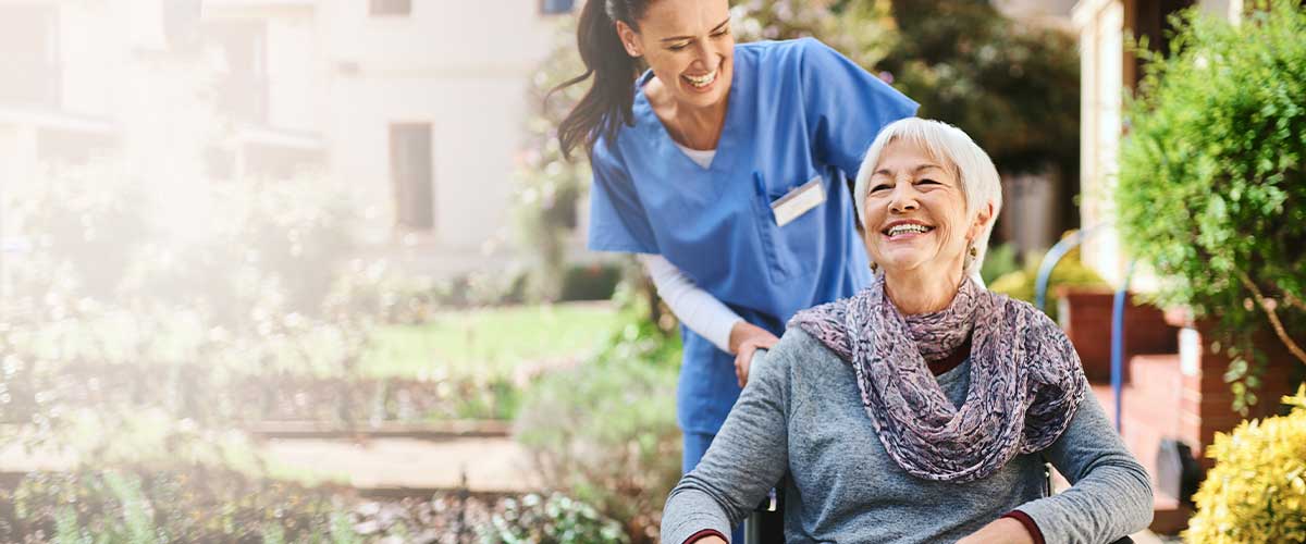 Nurse pushing senior woman in a wheelchair