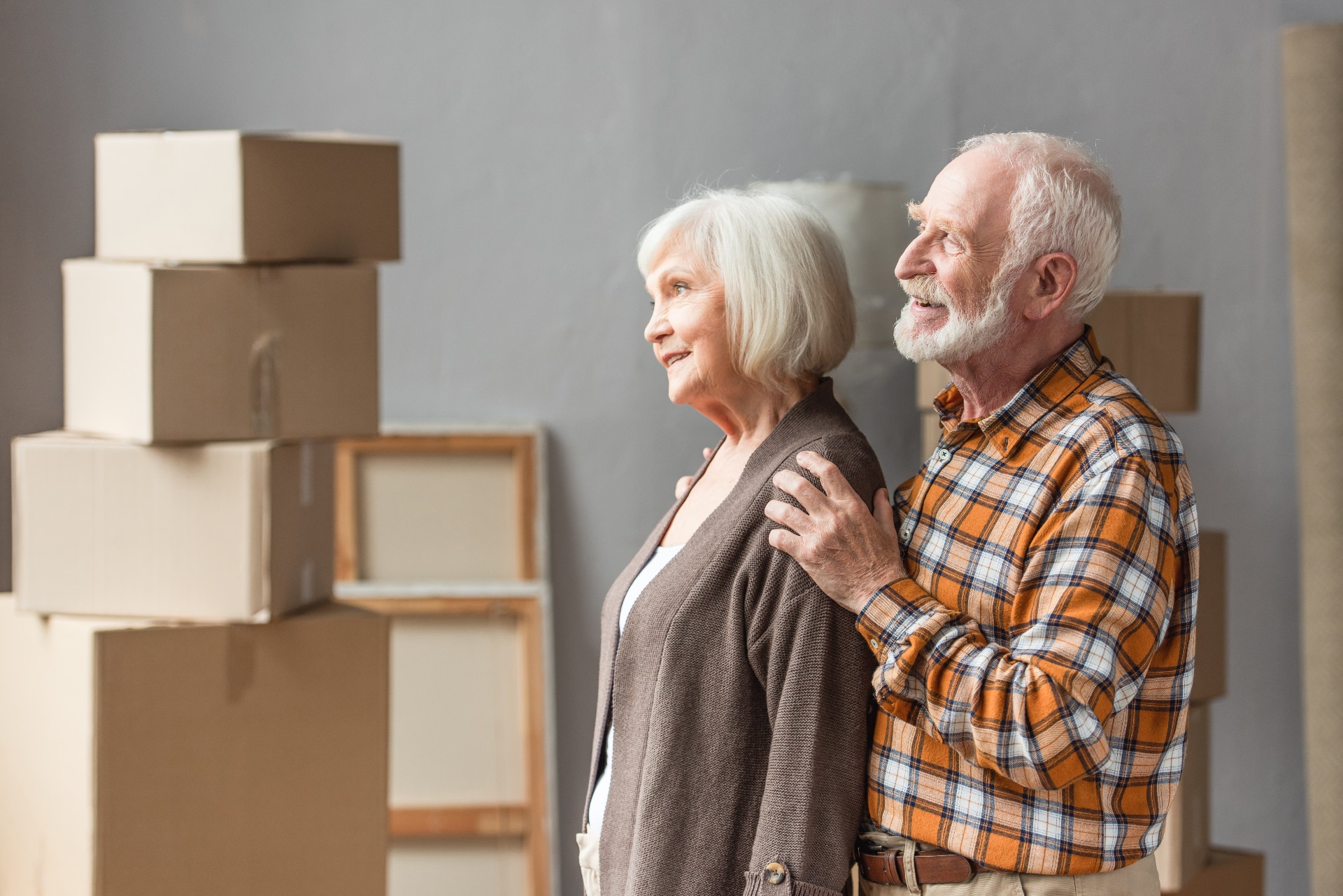 senior couple with packed moving boxes