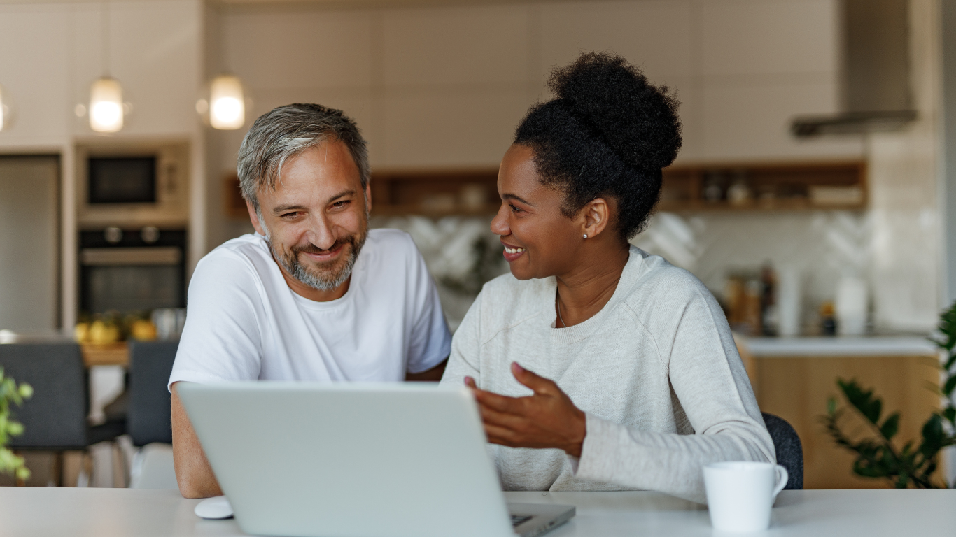 A middle aged couple looking at a laptop together