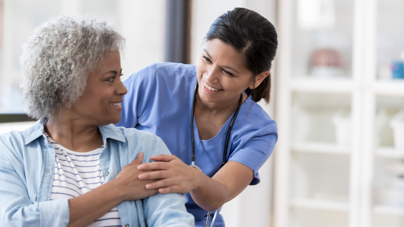 Senior woman and healthcare worker embracing