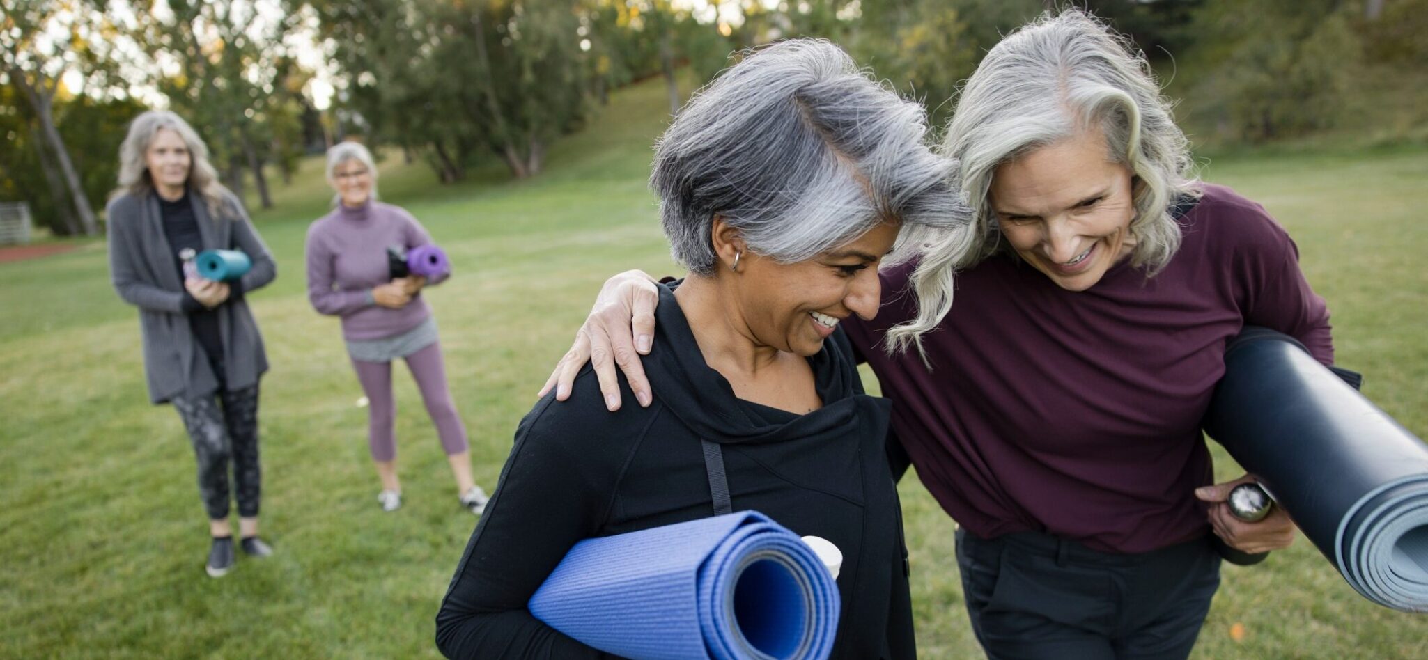 senior friends walking with yoga mats