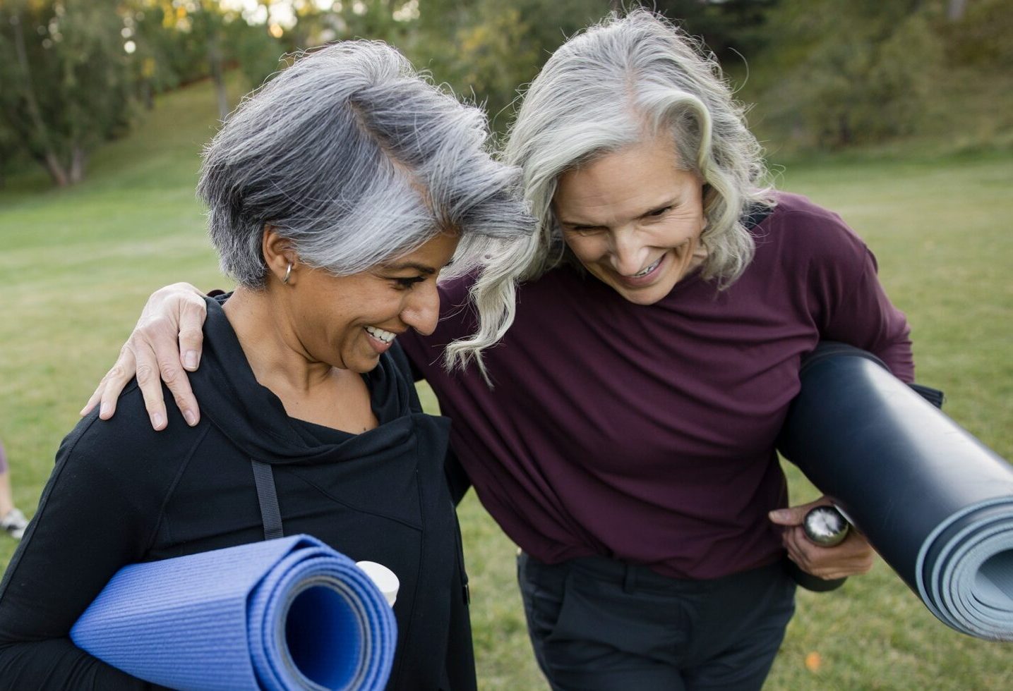 senior friends walking with yoga mats