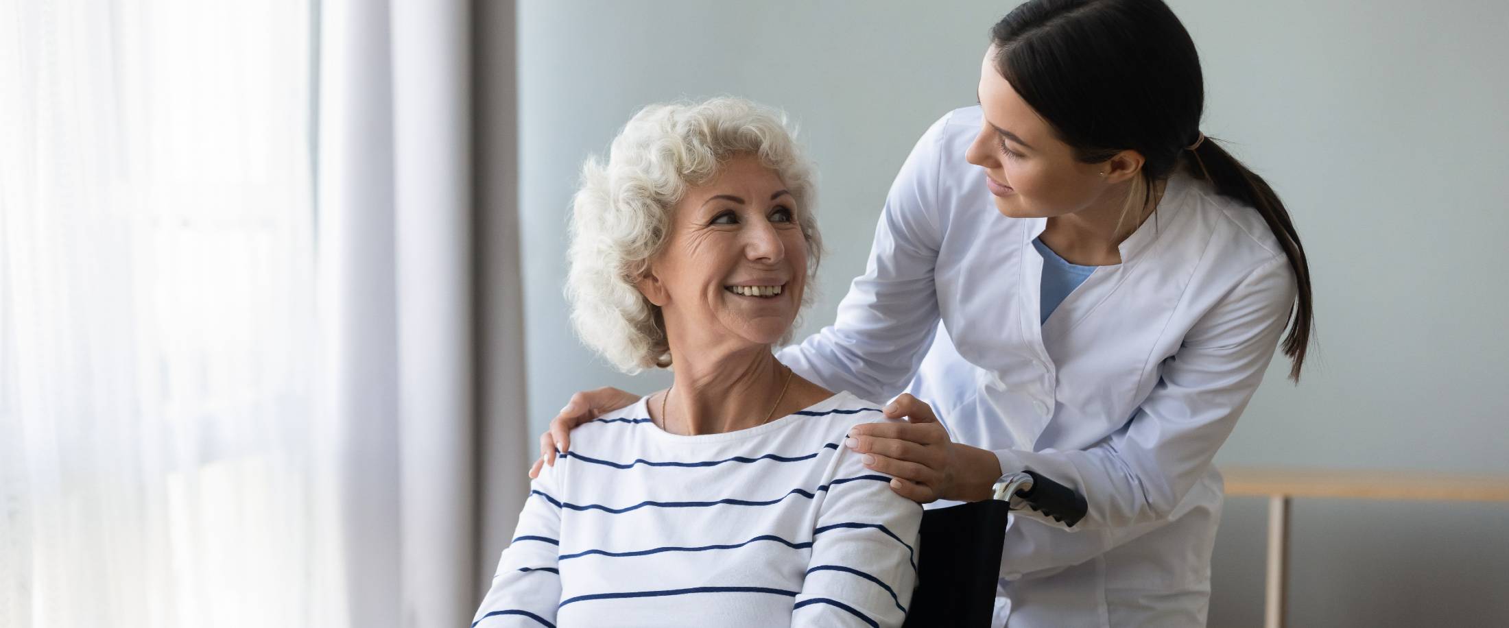 Senior woman smiling at female healthcare worker