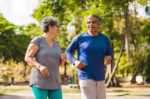 Senior couple running at park