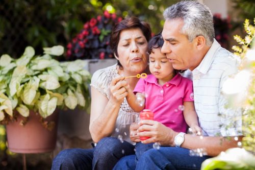 Grandparents and granddaughter making bubbles
